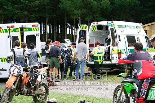 Ambulances and ambulance officers attending to motocross injuries at sporting event, New Zealand (NZ)