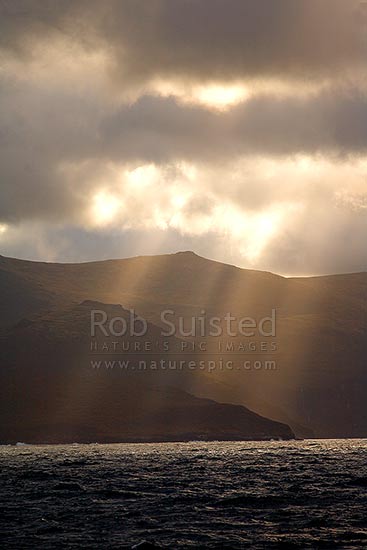 Shafts of sunlight above the Falla Peninsula, and main Auckland Islands. World Heritage site, Auckland Islands, NZ Sub Antarctic District, NZ Sub Antarctic Region, New Zealand (NZ)