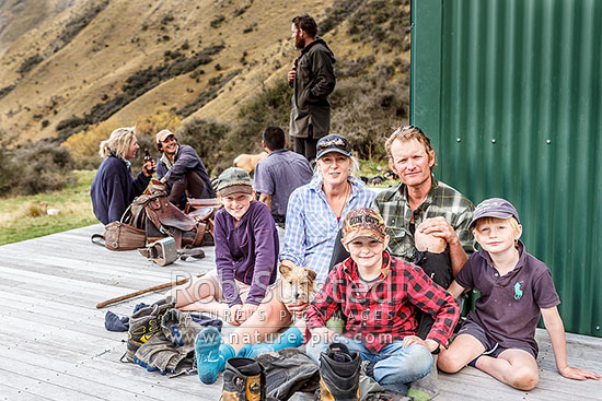 Georgina and James Murray, managers of The Branches Station, with kids (Annabel, Arthur and Dougal) at Sixteen Mile Hut, during the autumn muster, with musterers behind, Branches Station, Shotover Valley, Queenstown Lakes District, Otago Region, New Zealand (NZ)