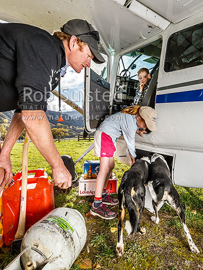 James Murray pilots the family plane, and essential tool in this remote back country. Here Annabel helps load up the plane for the autumn muster. Dogs love flying in the belly pod, Branches Station, Shotover Valley, Queenstown Lakes District, Otago Region, New Zealand (NZ)