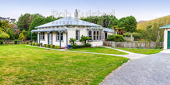 Old neatly kept farmhouse, garage and lawn, with childrens toys about. Panorama, New Zealand (NZ)