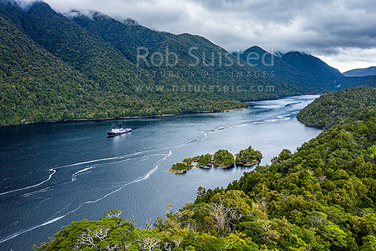 Cascade Cove, off Cook Channel in Dusky Sound. Ship anchored in the protected anchorage. Aerial view, Dusky Sound, Fiordland National Park, Southland District, Southland Region, New Zealand (NZ)