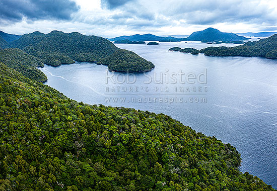 Pickersgill Harbour and Astronomer Point (left) nestled inside of Crayfish Island. Harbour used extensively by Captain Cook and the Resolution in 1773. Aerial view, Dusky Sound, Fiordland National Park, Southland District, Southland Region, New Zealand (NZ)