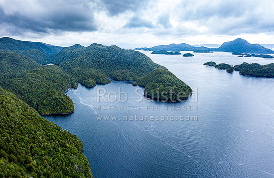 Pickersgill Harbour and Astronomer Point (left) nestled inside of Crayfish Island. Harbour used extensively by Captain Cook and the Resolution in 1773. Aerial view, Dusky Sound, Fiordland National Park, Southland District, Southland Region, New Zealand (NZ)