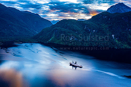 Supper Cove and the Seaforth River entering Dusky Soundat left. Sun rising behind Mt Solitary (1454m) right. Aerial view at dawn, Dusky Sound, Fiordland National Park, Southland District, Southland Region, New Zealand (NZ)