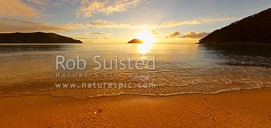 Onetahuti Bay beach sunrise, with sun rising behind Tonga Island, Tonga Roadstead on a beautiful calm summer morning. Golden sand beach, Abel Tasman National Park, Tasman District, Tasman Region, New Zealand (NZ)