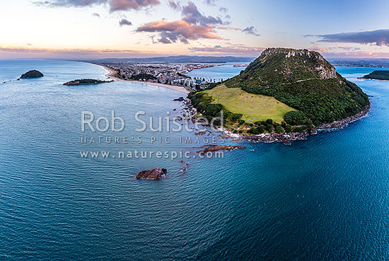 Mount Maunganui, or Mauao, at the Tauranga Harbour Entrance. 231m high lava dome. Moturiki and Motuotau Islands at left. Aerial view at dusk, Mount Maunganui, Tauranga District, Bay of Plenty Region, New Zealand (NZ)