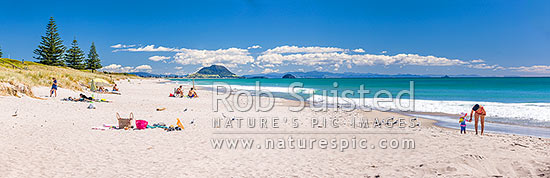 Papamoa Beach on a summer day with people enjoying the summer sunshine. Looking west towards Mt Maunganui Mauao (231m). Panorama, Papamoa Beach, Tauranga District, Bay of Plenty Region, New Zealand (NZ)