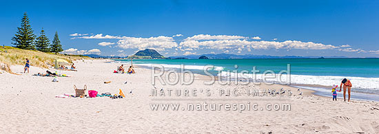 Papamoa Beach on a summer day with people enjoying the summer sunshine. Looking west towards Mt Maunganui Mauao (231m). Panorama, Papamoa Beach, Tauranga District, Bay of Plenty Region, New Zealand (NZ)