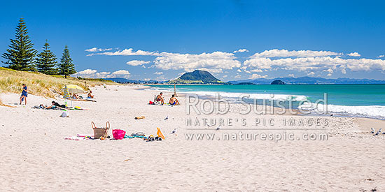 Papamoa Beach on a summer day with people enjoying the summer sunshine. Looking west towards Mt Maunganui Mauao (231m). Panorama, Papamoa Beach, Tauranga District, Bay of Plenty Region, New Zealand (NZ)