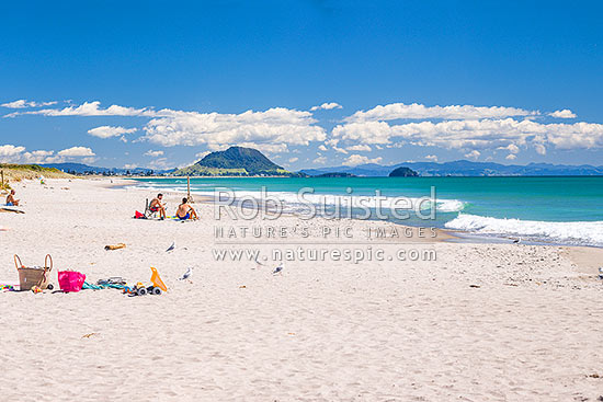 Papamoa Beach on a summer day with people enjoying the summer sunshine. Looking west towards Mt Maunganui Mauao (231m), Papamoa Beach, Tauranga District, Bay of Plenty Region, New Zealand (NZ)