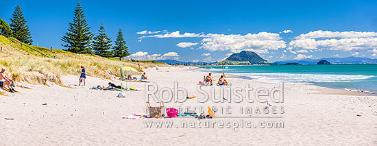 Papamoa Beach on a summer day with people enjoying the summer sunshine. Looking west towards Mt Maunganui Mauao (231m). Panorama, Papamoa Beach, Tauranga District, Bay of Plenty Region, New Zealand (NZ)