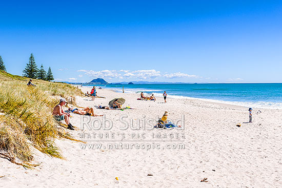 Papamoa Beach on a summer day with people enjoying the summer sunshine. Looking west towards Mt Maunganui Mauao (231m), Papamoa Beach, Tauranga District, Bay of Plenty Region, New Zealand (NZ)