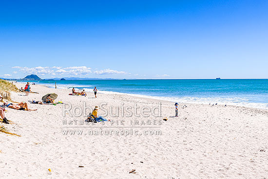 Papamoa Beach on a summer day with people enjoying the summer sunshine. Looking west towards Mt Maunganui Mauao (231m), Papamoa Beach, Tauranga District, Bay of Plenty Region, New Zealand (NZ)