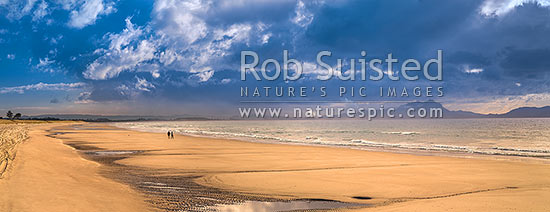 Ruakaka Beach panorama, with people walking in evening light. Mt Manaia (right, 420m) behind right, at the Whangarei Harbour Heads, Ruakaka, Whangarei District, Northland Region, New Zealand (NZ)