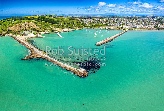 Oamaru harbour breakwater and Holmes Wharf enclosing Friendly Bay. Oamaru town at right, Cape Wanbrow, and Oamaru Blue Penguin Colony at left. Aerial view, Oamaru, Waitaki District, Canterbury Region, New Zealand (NZ)