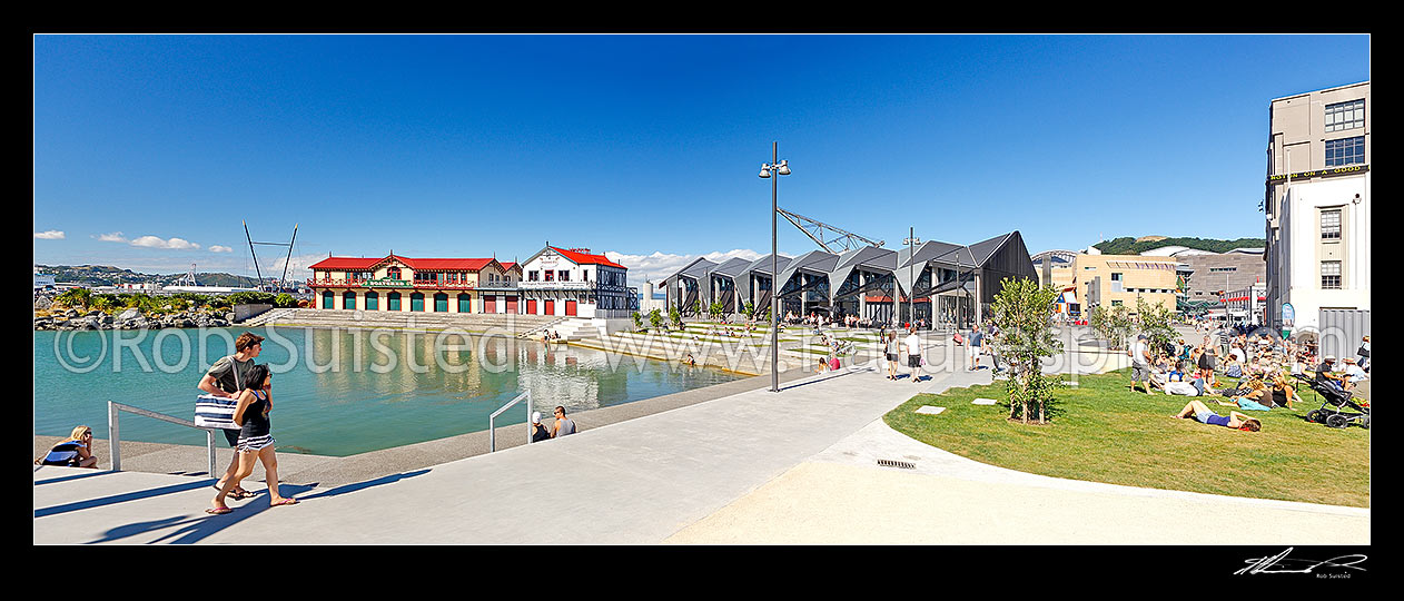 Image of Wellington waterfront city lagoon with historic Rowing and Boating club, Wharewaka, Odlins and St Johns Ambulance buildings, and people enjoying summer. Panorama, Wellington, Wellington City District, Wellington Region, New Zealand (NZ) stock photo image