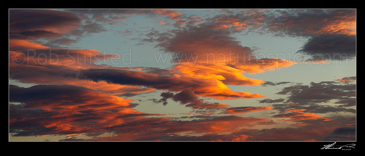 Image of Unusual fiery orange sunset clouds in an evening sky. Panorama file, New Zealand (NZ) stock photo image